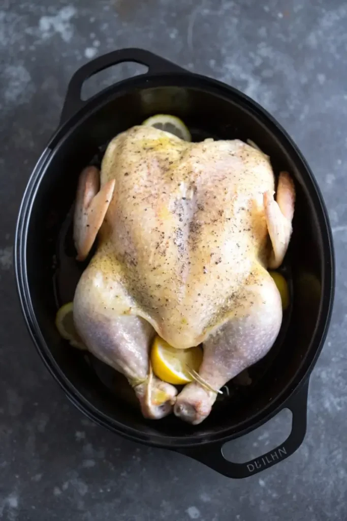 Low FODMAP Roasted Lemon Chicken in cast iron pot with lemon slices and rosemary before serving